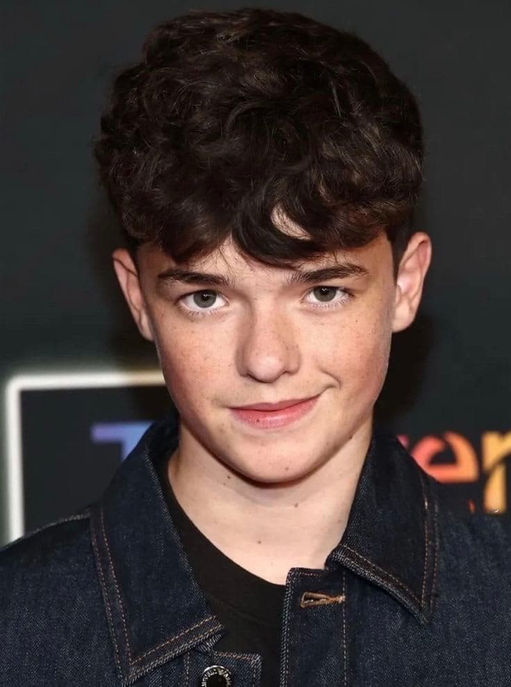 Close-up portrait of British actor Owen Cooper wearing a dark denim jacket